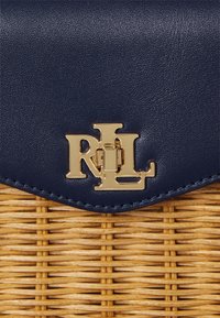 Mornarska kožna torba s tkanom slamnatom podlogom, s zlatnim "RL" logotipom i ukrasnim šavovima duž rubova.