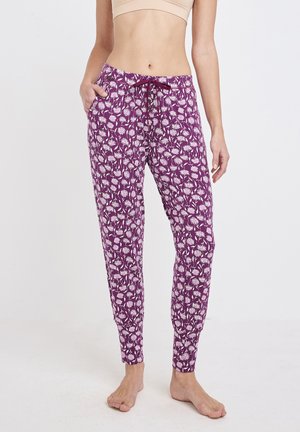 Pantalones de pijama morados con un patrón floral blanco, hechos de tela suave. Cuentan con una cinturilla elástica y bolsillos laterales. Puños ajustados en los tobillos.