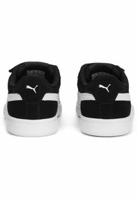 Baskets en suédine noire et textile avec des accents blancs, talon arrondi et logo à l'arrière. Langue et col rembourrés pour plus de confort.