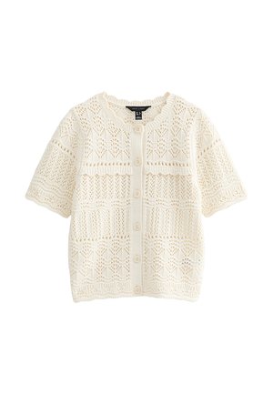 Cárdigan corto de punto color crema con mangas cortas, cierre frontal con botones y patrones de encaje intrincados por todo el tejido.