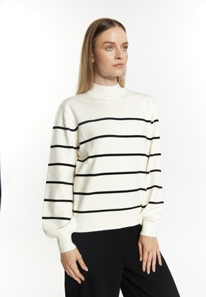 Pull blanc en tricot avec des rayures horizontales noires, col haut et manches longues bouffantes. Le tissu semble doux ; design décontracté.