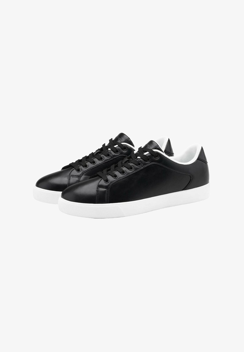 Baskets en cuir noir avec une finition lisse, semelles en caoutchouc blanches, bout rond et lacets noirs. Comprend un col et une languette rembourrés blancs.