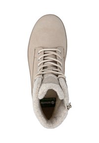 Botín de ante beige con forro de pelo texturizado, punta redonda y cordones planos. Presenta ojetes metálicos y un parche con el logotipo en la lengüeta.