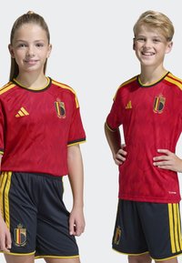 Röda sporttröjor med flammönster, med gula accenter och kronor. Svarta shorts med gula ränder och lagets emblem.