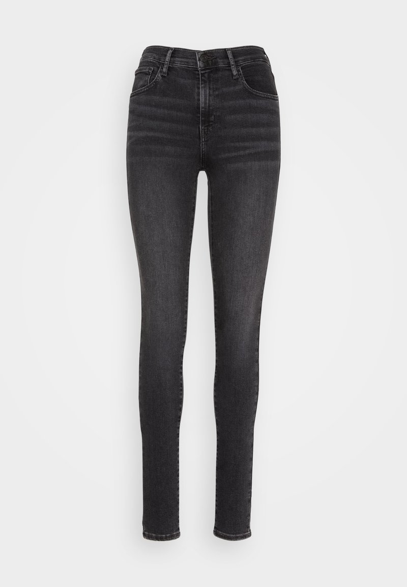Jean slim en denim noir, avec une taille haute, cinq poches, et un léger délavage sur le devant pour une texture et un style distincts.