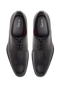 Scarpe da uomo in pelle nera con una texture liscia, caratterizzate da una punta arrotondata, chiusura con lacci e cuciture tonali sottili. Logo ALDO visibile all'interno.