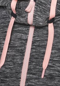 Gray hoodie with a soft texture, featuring a pink zipper and matching drawstrings. Notable details include a branded tag and textured fabric.