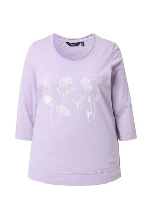 Camiseta lila de manga tres cuartos con diseños florales en línea blanca en el pecho y cuello redondo.