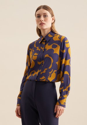 Camicia a maniche lunghe di colore blu navy e senape con motivo astratto, apertura con bottoni e colletto classico. Tessuto leggero con texture morbida.