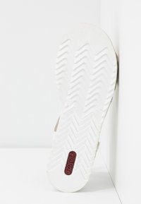Semelle de sandale en caoutchouc blanc avec un motif de semelle en zigzag et un logo "rieker" rouge. Bords lisses et arrondis; conception légère.