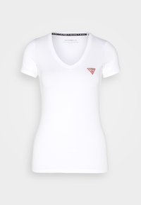 Camiseta blanca de cuello en V hecha de algodón, con mangas cortas y un pequeño logo rojo en forma de triángulo en la parte izquierda del pecho.