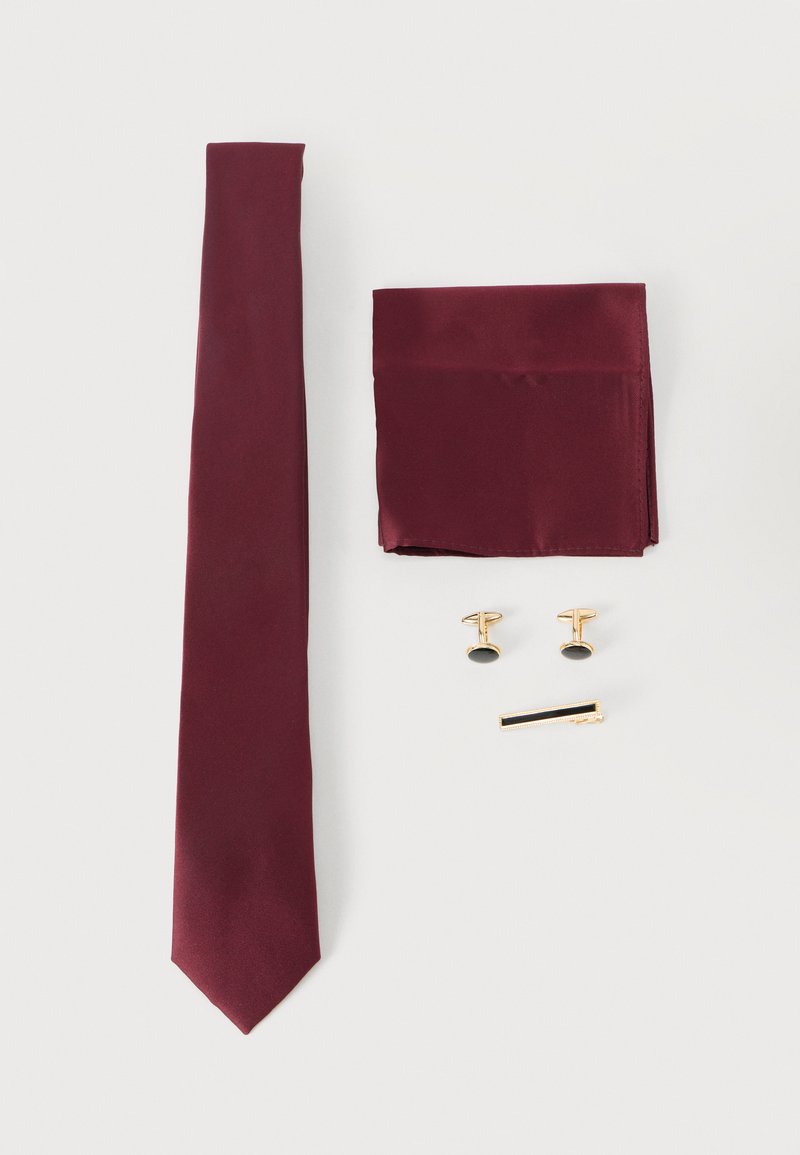 Cravate en soie bordeaux, pochette assortie, boutons de manchette dorés avec inserts noirs, et pince à cravate dorée avec un accent noir, sur un fond blanc.