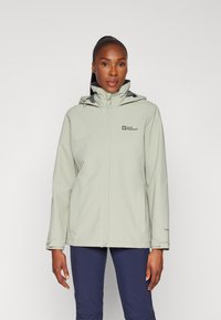 Light green waterproof jacket with a high collar, adjustable hood, and front zip closure. Features logo detail on the chest and side pockets.