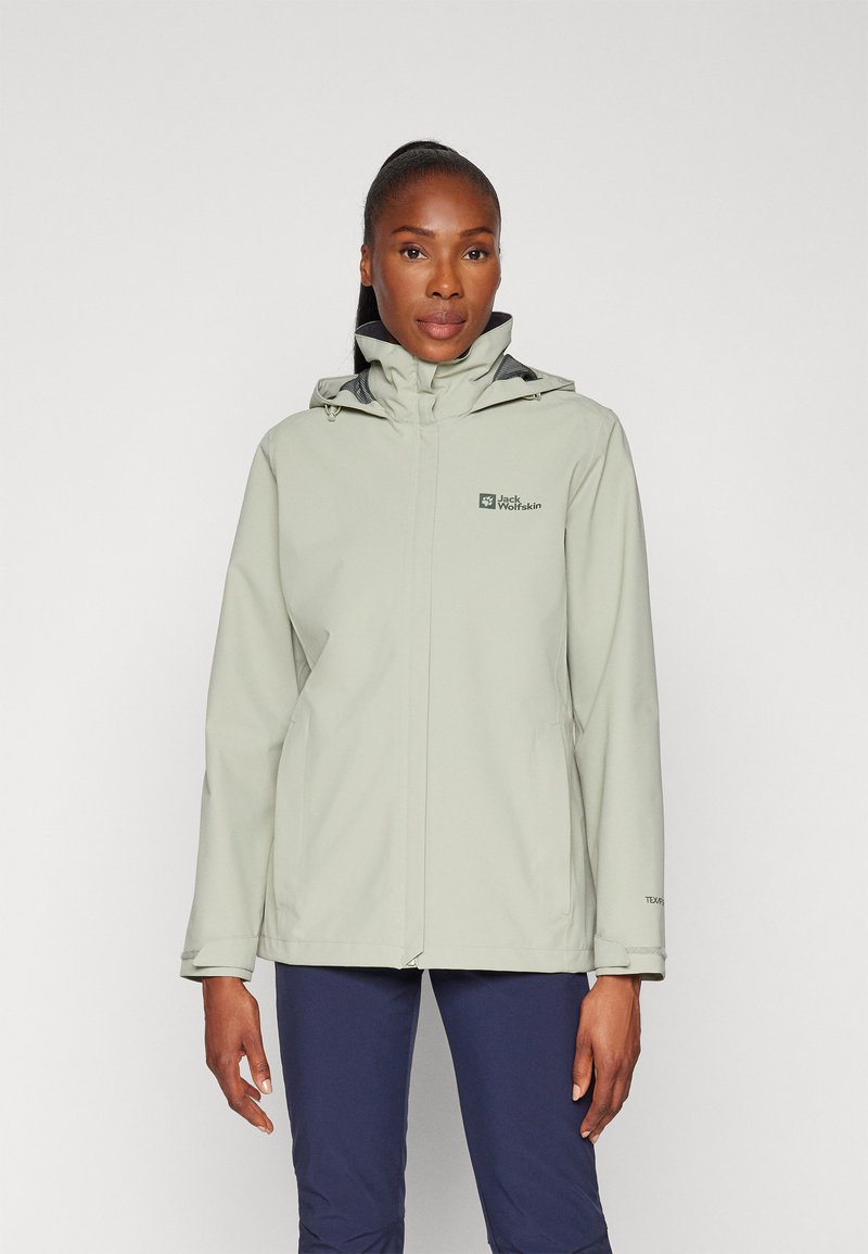 Light green waterproof jacket with a high collar, adjustable hood, and front zip closure. Features logo detail on the chest and side pockets.