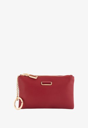 Cartera de cuero rojo con cadena y cremallera en tono dorado. Tiene forma rectangular y un pequeño detalle metálico en la parte delantera.