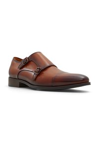Brune læder monk strap sko med dobbelt justerbare spænder, rund tå og glat finish. Moderat stablet hæl og slankt design.