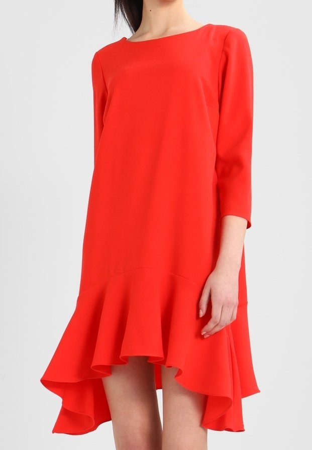 Vestido rojo con mangas de tres cuartos, cuello redondeado, tejido ligero y fluido, y un dobladillo asimétrico con borde con volantes.