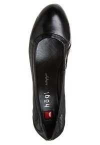 Chaussure plate en cuir noir avec un bout arrondi et une ouverture élastiquée. Présente une texture lisse, une semelle intérieure avec logo et un petit accent rouge.
