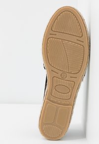 Semelle d'une chaussure taille 37 avec une bande de roulement en caoutchouc texturé et "Made in Spain" embossé près du talon, présentée sur fond blanc.