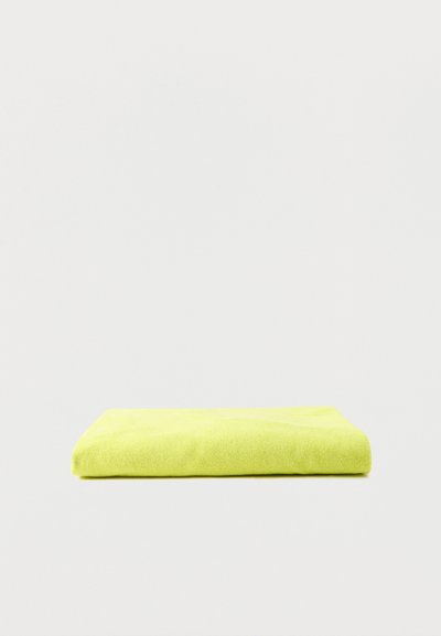 Serviette pliée de couleur jaune vif posée à plat sur une surface gris clair sans autres objets ni détails de fond.