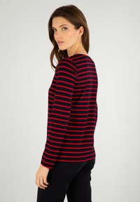 Langærmet skjorte i marineblå og rød striber med rund halsudskæring, der har en afslappet pasform og en glat stoftekstur.