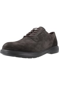 Scarpe eleganti in suede grigio scuro con punta rotonda, design con lacci e suola in gomma nera. Presentano un branding sottile sul lato superiore.