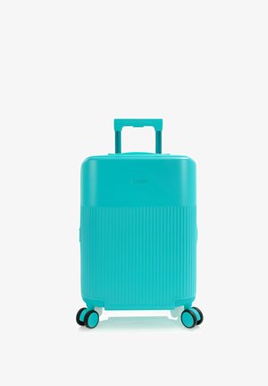 Türkisfarbener Hartschalenkoffer mit vertikalen Rillen, Teleskopgriff und vier doppelt drehbaren Rollen auf weißem Hintergrund.