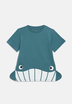 T-shirt bleu à manches courtes pour enfants avec motif visage de baleine et nageoires latérales s’étendant à partir de l’ourlet.