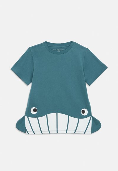 T-shirt bleu à manches courtes pour enfants avec motif visage de baleine et nageoires latérales s’étendant à partir de l’ourlet.