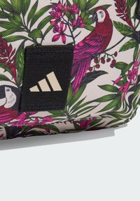 Zaino floreale in tessuto sintetico con pappagalli rosa e foglie verdi. Include una toppa con logo nero con tre strisce bianche.