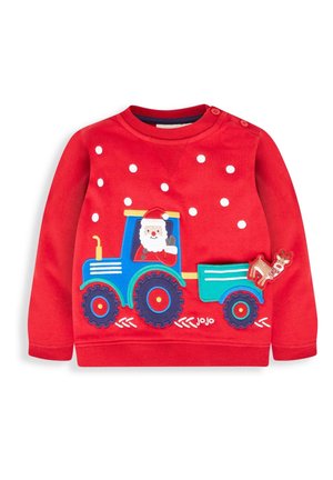 Roter Kinderpullover mit blauem Traktor, der den Weihnachtsmann und ein Rentier transportiert, vorne mit weißen Schneeflocken verziert.