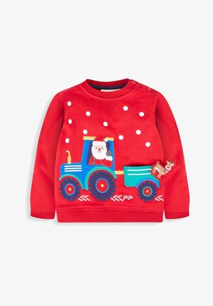 Czerwony sweter dziecięcy z niebieskim traktorem, na którym jadą Mikołaj i renifer, ozdobiony białymi płatkami śniegu na przodzie.