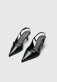 Melni ādas blokka papēžu zābaki ar smailiem purngaliem, plānām potīšu siksnām un maziem blokveida papēžiem. Gluda tekstūra un minimālistisks dizains.