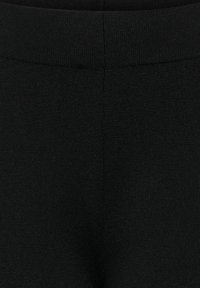 Zwarte joggers van een gestructureerde stof, met een elastische tailleband en een gladde oppervlakte met subtiele naden, ontworpen voor comfort en flexibiliteit.