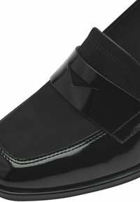 Mocassin noir doté d'une tige en cuir lisse, d'une large bande sur le devant et d'une finition brillante avec des accents mats contrastants.