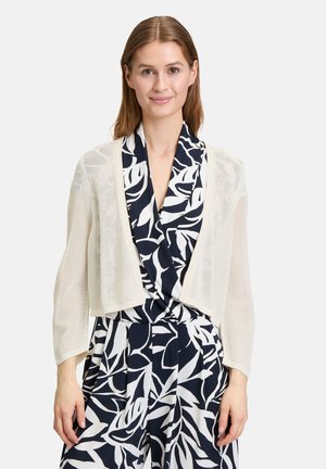 Gilet en crochet léger crème, présentant un design court à devant ouvert avec des manches longues et un tissu texturé, respirant.