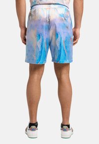Bañadores en tonos azules con un colorido patrón floral, cinturilla elástica y detalles de bolsillo trasero. Material ligero.