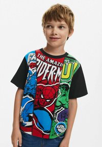 T-shirt featuring comic book characters, predominantly in red, blue, and green colors. Short sleeves, crew neck, with graphic prints and diverse patterns.