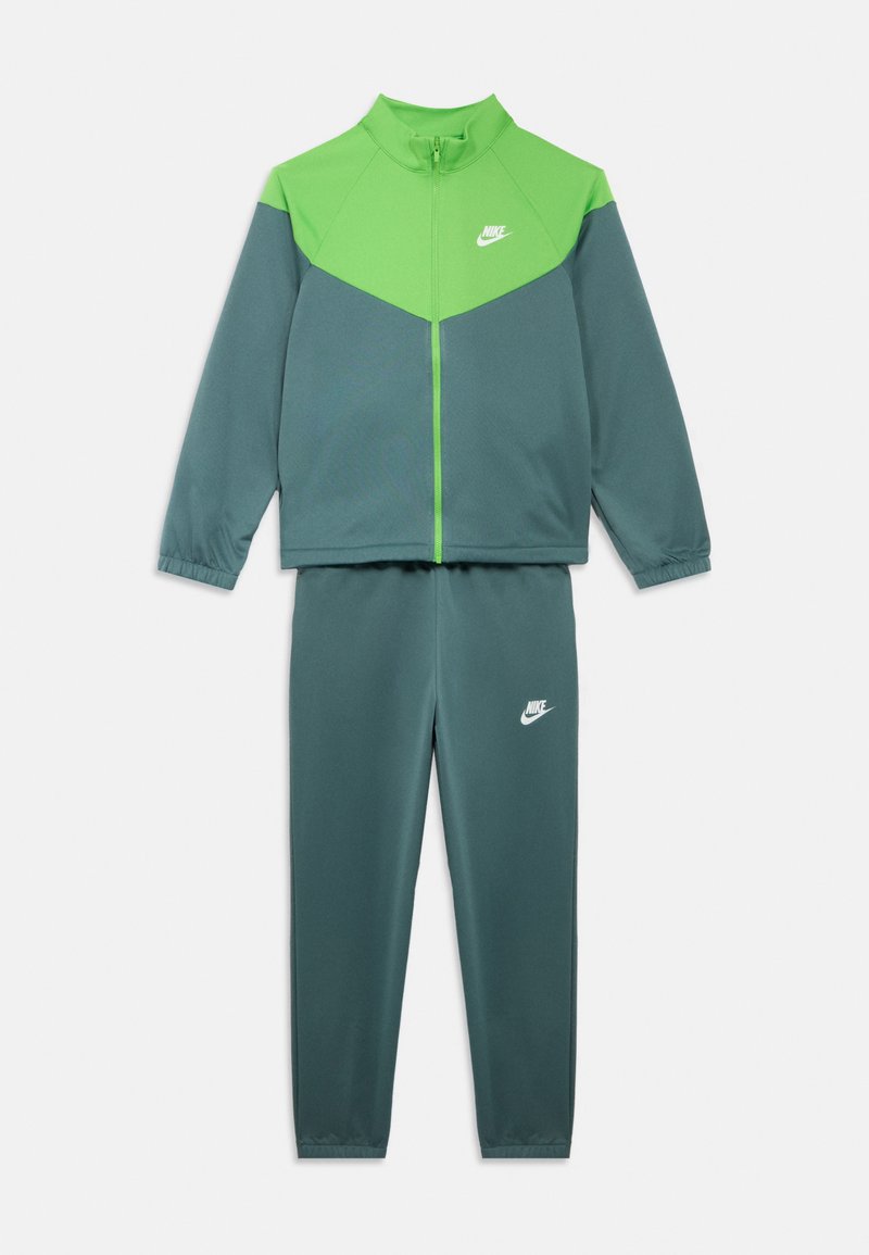 Grønn og grå treningsdress med glidelåsjakke og bukser med elastisk linning. Har Nike-logo på jakken og buksene. Jevn tekstur.