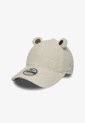 Casquette beige en fourrure avec des accents d'oreilles, texture douce, visière courbée et un patch logo circulaire sur le devant. Convient pour les tailles jeunesse.