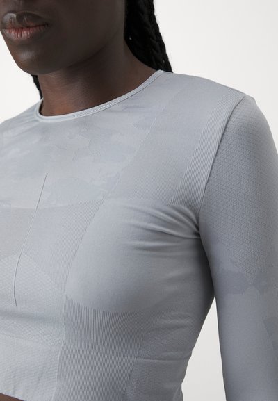 Light gray long-sleeve athletic top featuring varying textures, including ribbed and smooth sections, with a crew neckline and fitted design.