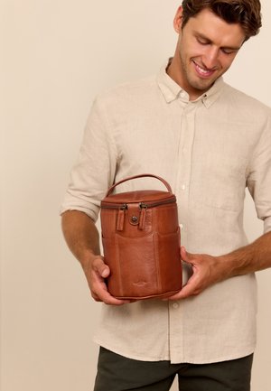 Braune Lederhandtasche mit Reißverschluss oben, abgerundeter Form, Seitentaschen und einem Griff. Material hat eine glatte Textur und einen leichten Glanz.