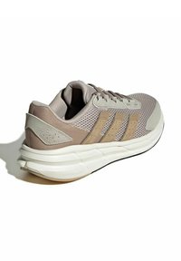 Scarpa da ginnastica beige con tomaia in mesh traspirante, tre strisce tonali, collarino imbottito e intersuola bianca ammortizzata.