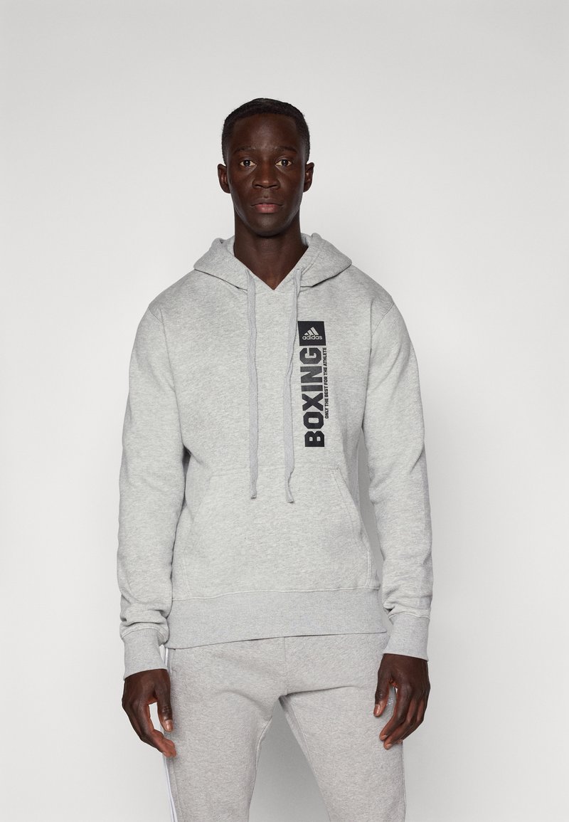 Felpa grigia con tasca frontale, cappuccio con cordino e grafica "BOXING" nera sul petto. Realizzata in materiale morbido con una vestibilità comoda.