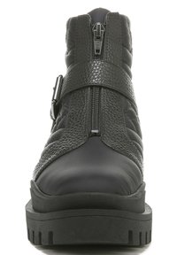 Zwarte enkellaarzen met een gewatteerde textuur en een glanzende afwerking. Voorzien van een zijrits en een verstelbare band over een stevige zool.