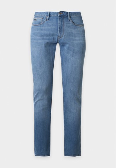 Φωτεινά γαλάζια τζιν σε slim fit με πέντε τσέπες και κλείσιμο με κουμπί, εμφανίζονται σε μια απλή γκρι φόντο.