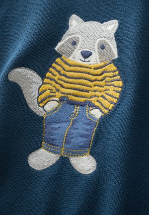 Geborduurd wasbeerontwerp op een blauwe achtergrond, gekleed in een geelgestreepte trui en spijkerbroek, met texturen en details in de stiksels.