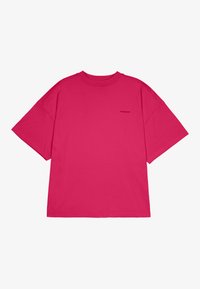 Pink oversized t-shirt made from cotton, featuring short sleeves, a crew neck, and a small logo detail on the chest.