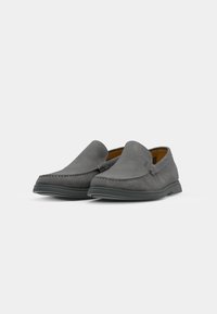 Zapatos slip-on de ante gris con una textura suave, que presentan detalles cosidos a lo largo de la costura y una suela de goma para mayor tracción.