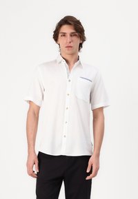Camisa blanca de manga corta con botones, fabricada en un tejido texturizado, un bolsillo en el pecho y un detalle a rayas en el cuello.